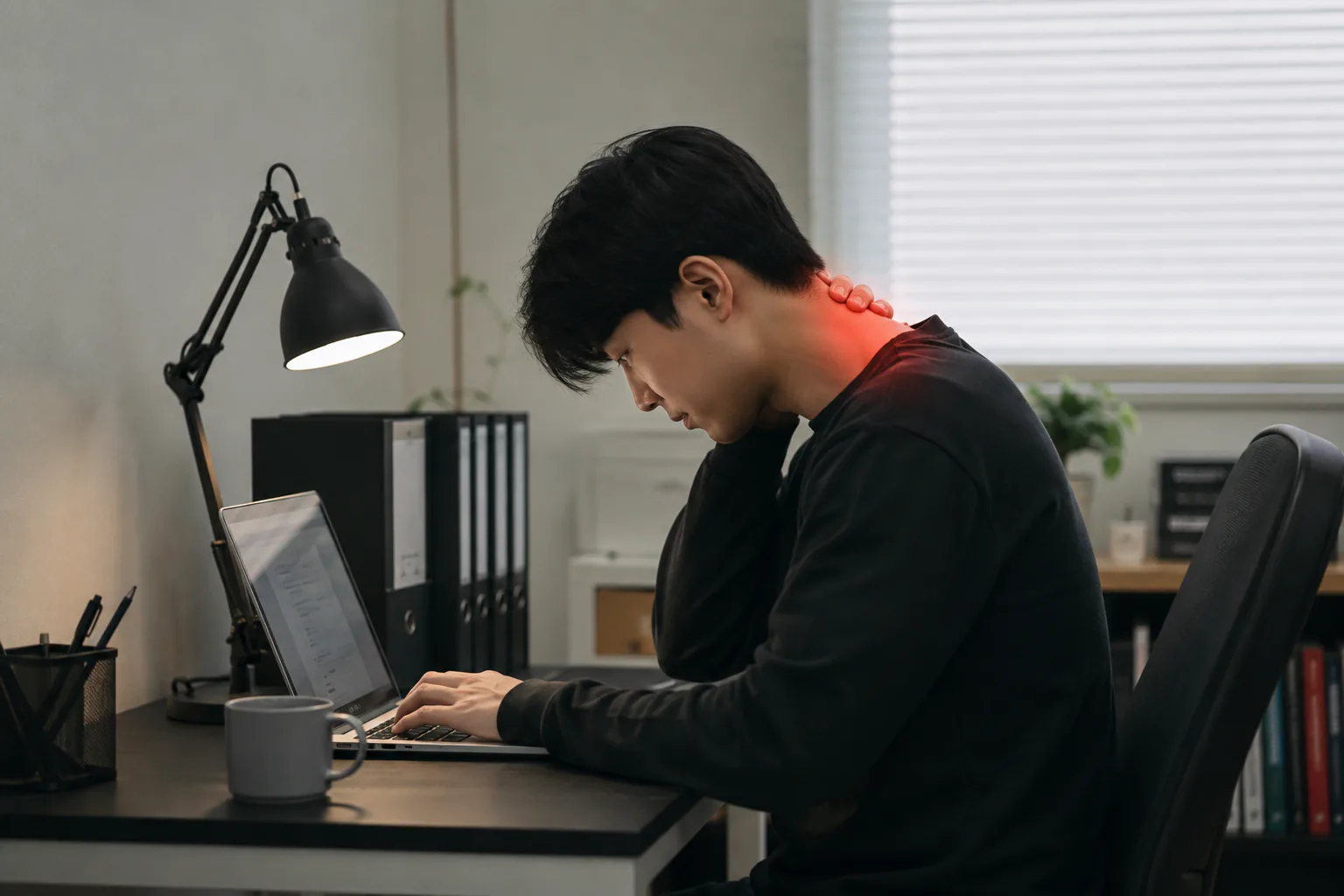 책상에서 고개 숙이고 노트북 보는 모습